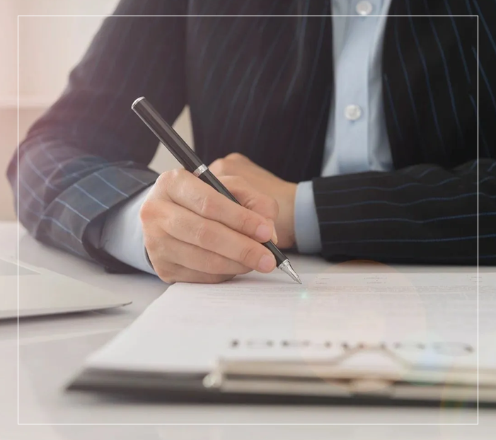 A person writing on paper with a pen.