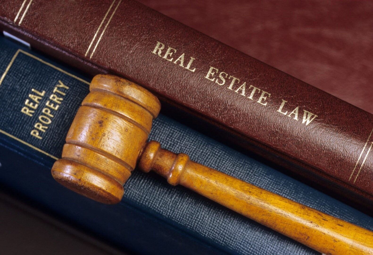 A wooden gavel sitting on top of two law books.